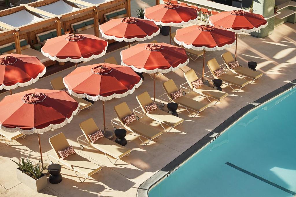 een uitzicht over de stoelen en parasols naast een zwembad bij Life House, Palm Springs in Palm Springs