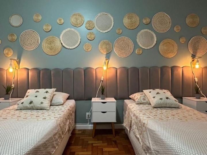 2 camas en una habitación con platos en la pared en Rio Belo, en Río de Janeiro