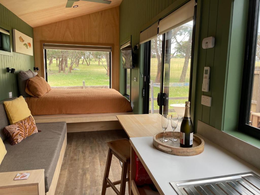 Habitación pequeña con cama y mesa con copas de vino en Marlo Hideaway, en Marlo