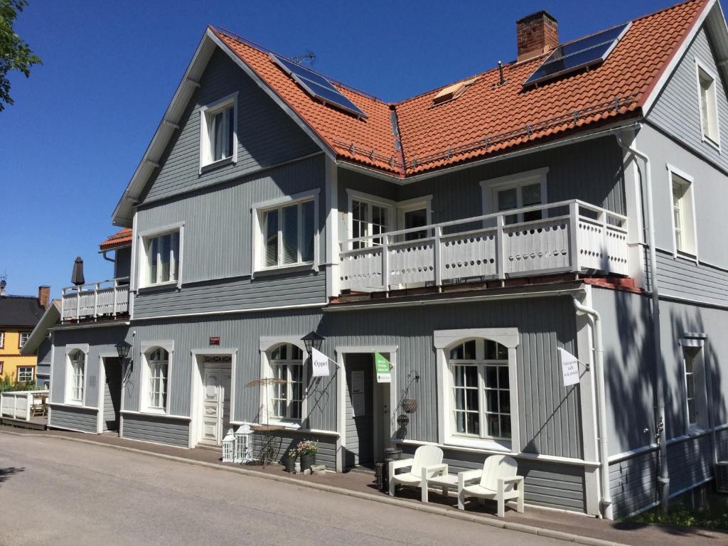 una casa gris y blanca con techo rojo en Vintergatans Rum, en Insjön