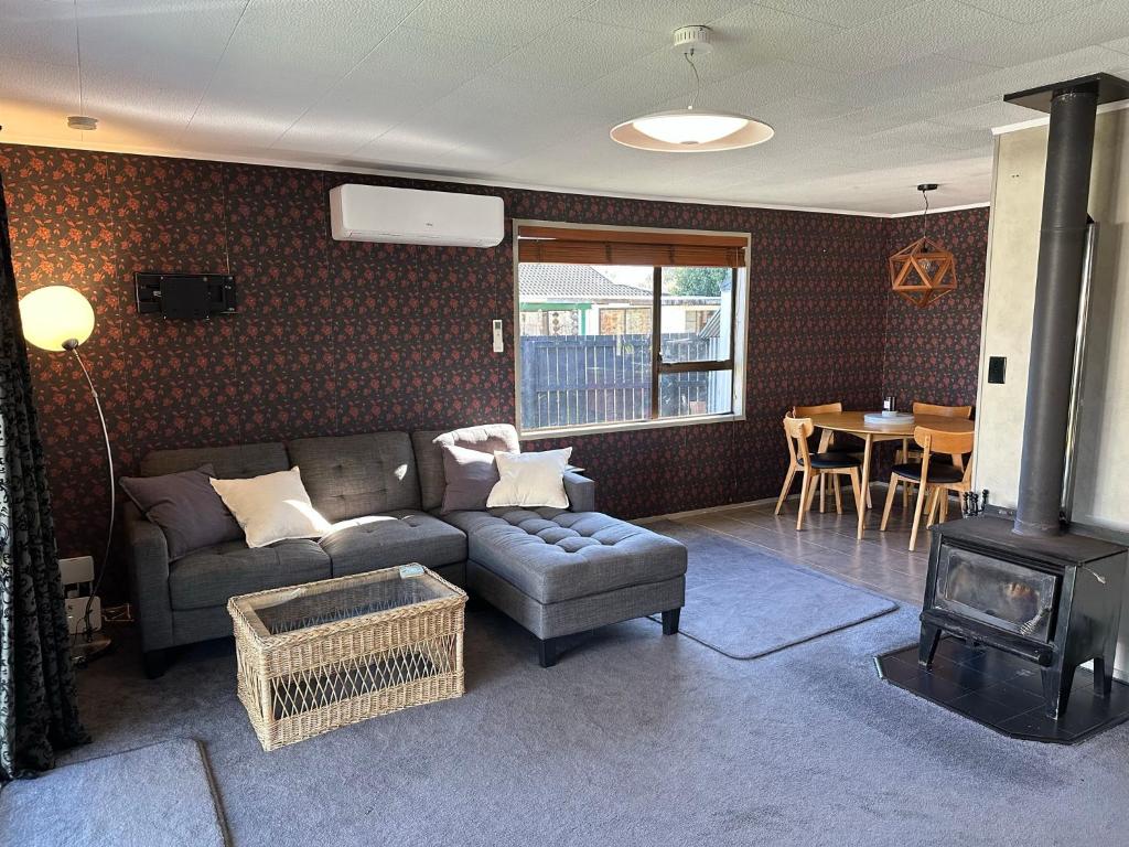 een woonkamer met een bank en een fornuis bij Streamside Family Friendly Oasis with Spa in Rotorua