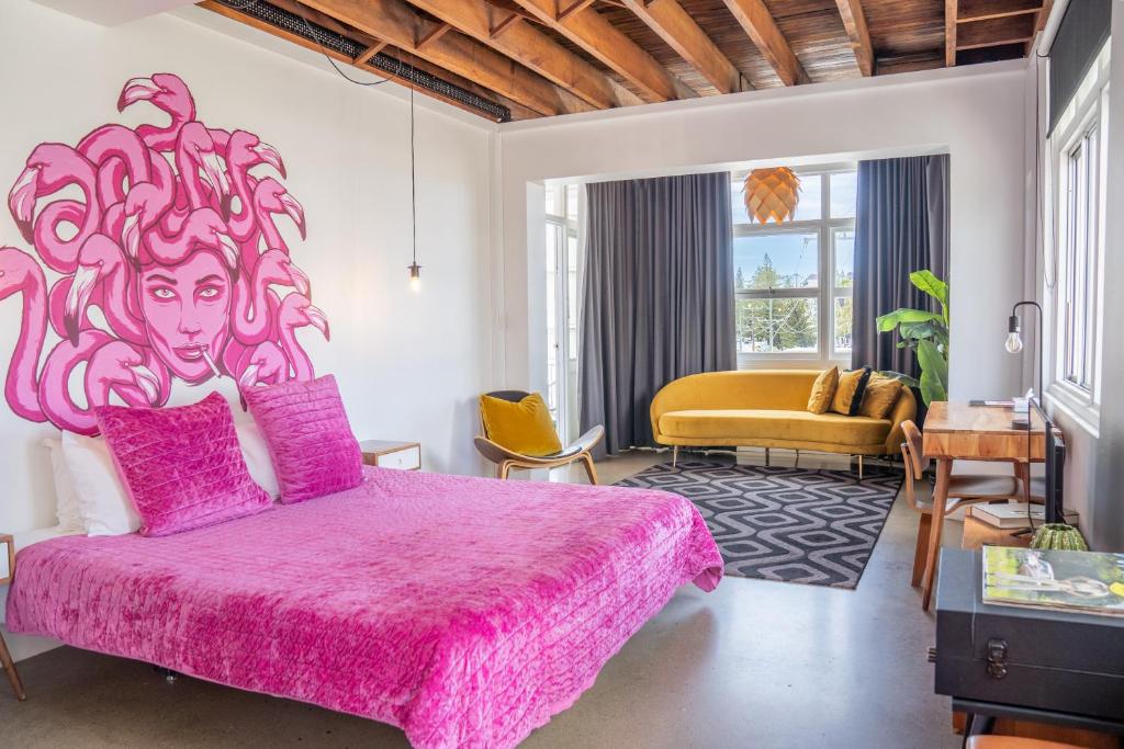 a bedroom with a pink bed with a headboard at The Pink Hotel Coolangatta in Gold Coast