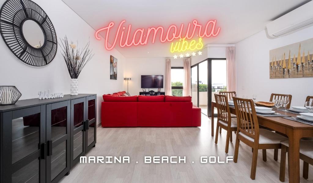 een woonkamer met een rode bank en een tafel bij Vilamoura - Spacious with Swimming Pool & View in Vilamoura