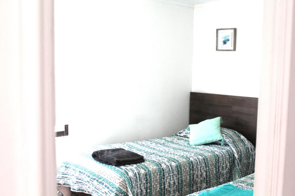 a bedroom with a bed with a blanket at Grandioso departamento a cuadras de Parque O'higgins in Santiago