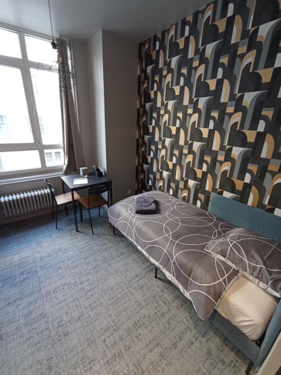um quarto com uma cama e uma secretária. em Le 12 saint Etienne neuf wifi app 04 em Saint-Étienne