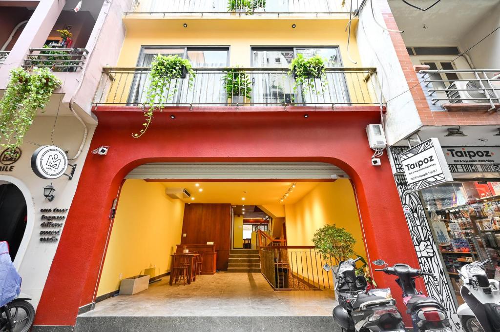 Saigon Hotel & Apartment في مدينة هوشي منه: مبنى احمر و اصفر مع شرفه و طاوله