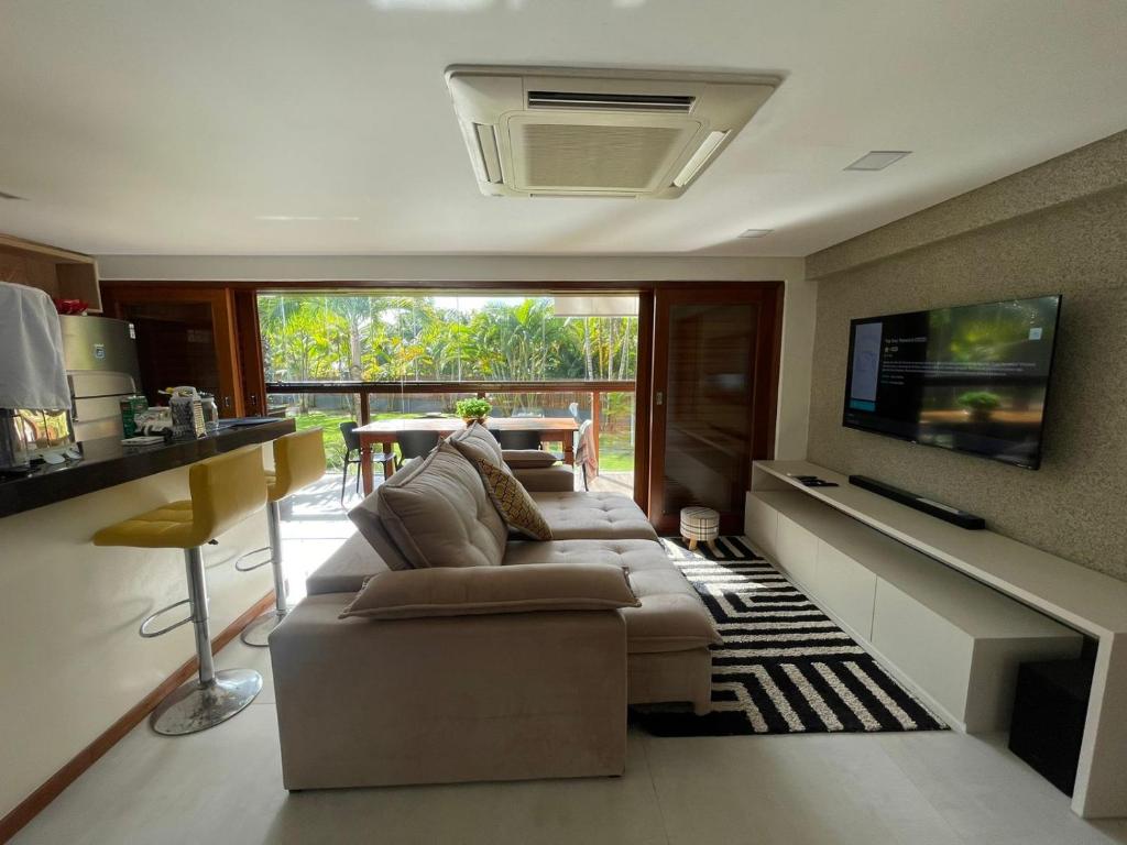 a living room with a couch and a tv at Barra Grande Exclusive Residence in Barra Grande