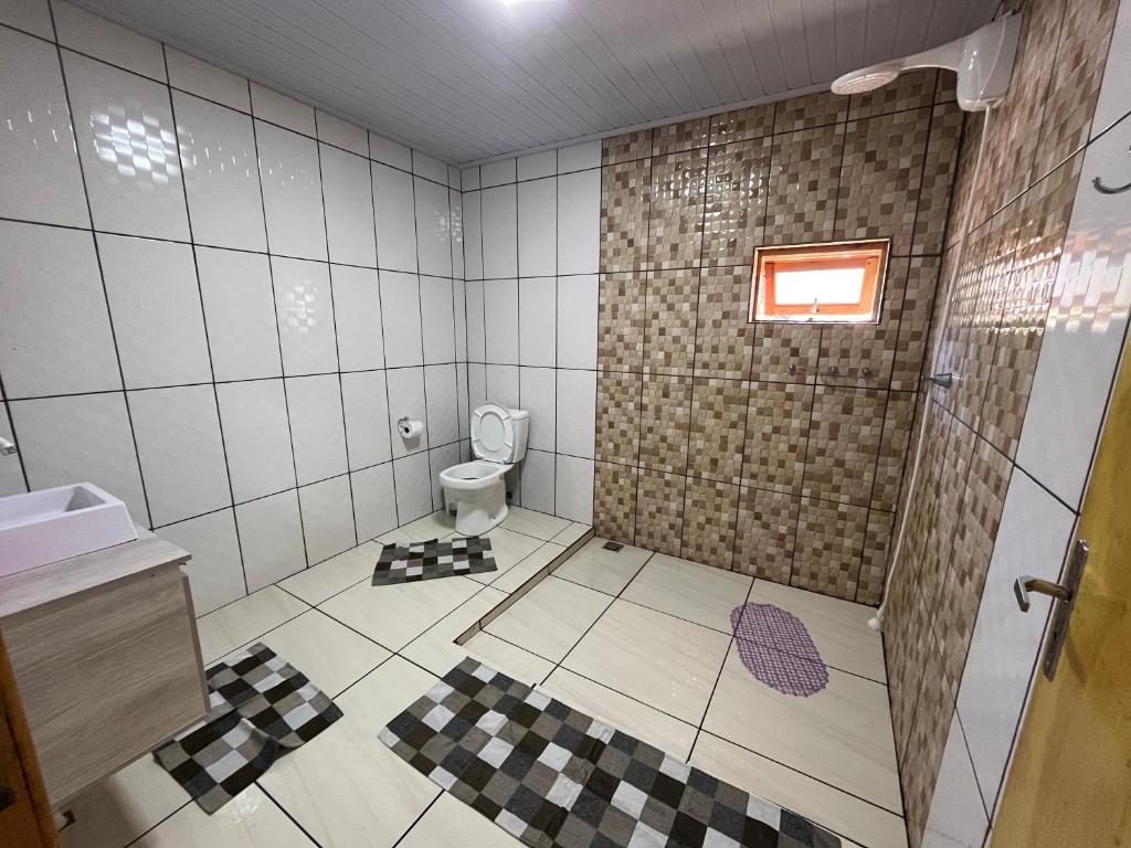 uma casa de banho com um chuveiro e um WC. em Cabanas Romeu & Julieta em Cambará