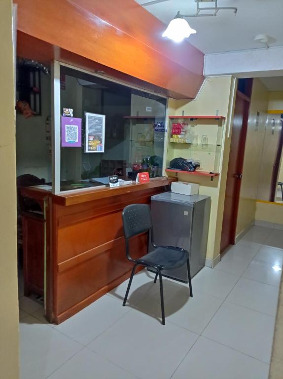 a chair sits in front of a reception desk at Hostal Cix - Chiclayo in Chiclayo