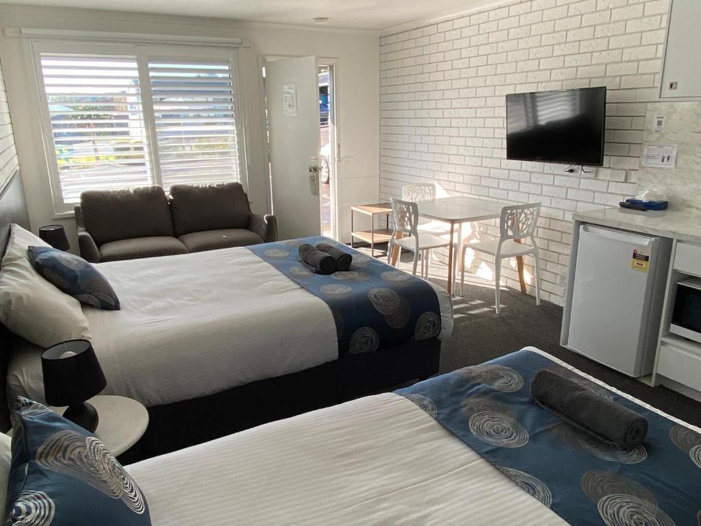 a hotel room with two beds and a television at Southern Ocean Motor Inn in Port Campbell