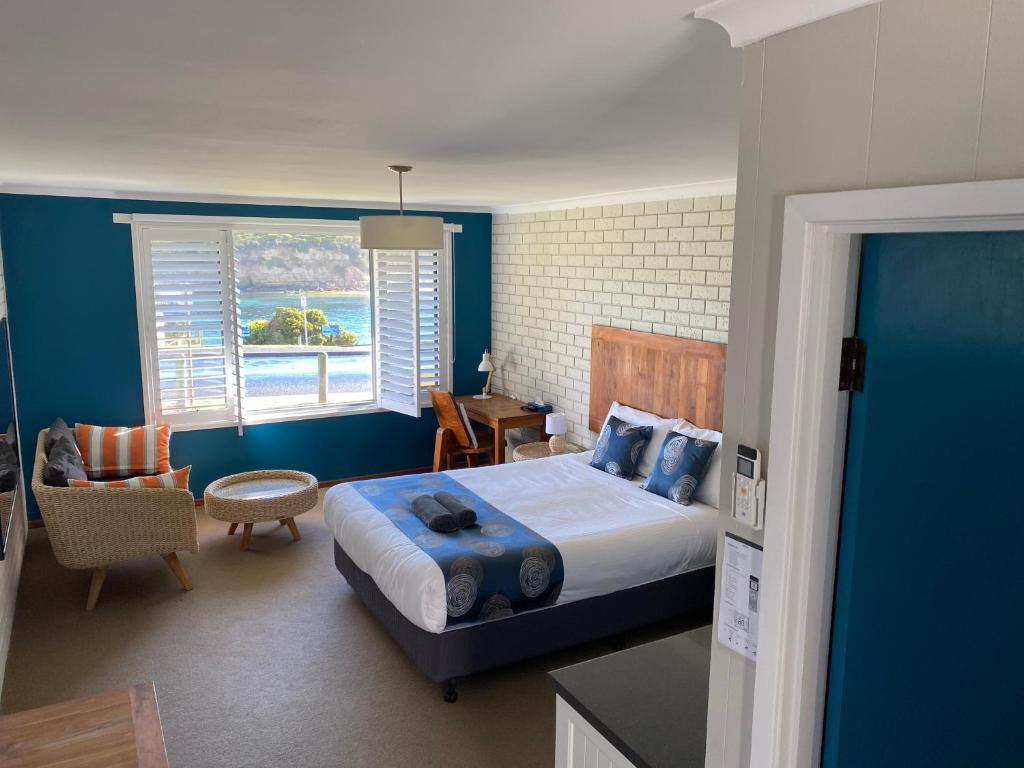 um quarto com uma cama grande e uma janela em Southern Ocean Motor Inn em Port Campbell