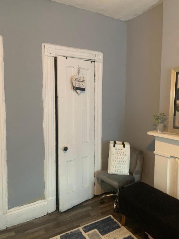 Zimmer mit einer weißen Tür und einem Stuhl in der Unterkunft Misty Blue in Brooklyn