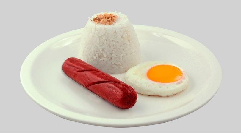 een bord met rijst en een ei en een worst bij Issa's Haven Resort in Look