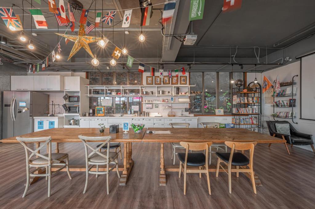 a kitchen with a large wooden table and chairs at Light Hostel - Tainan in Tainan