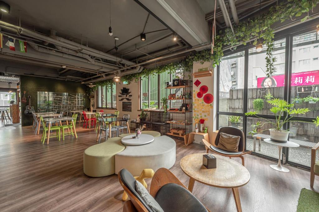 a room with tables and chairs and windows at Light Hostel - Tainan in Tainan