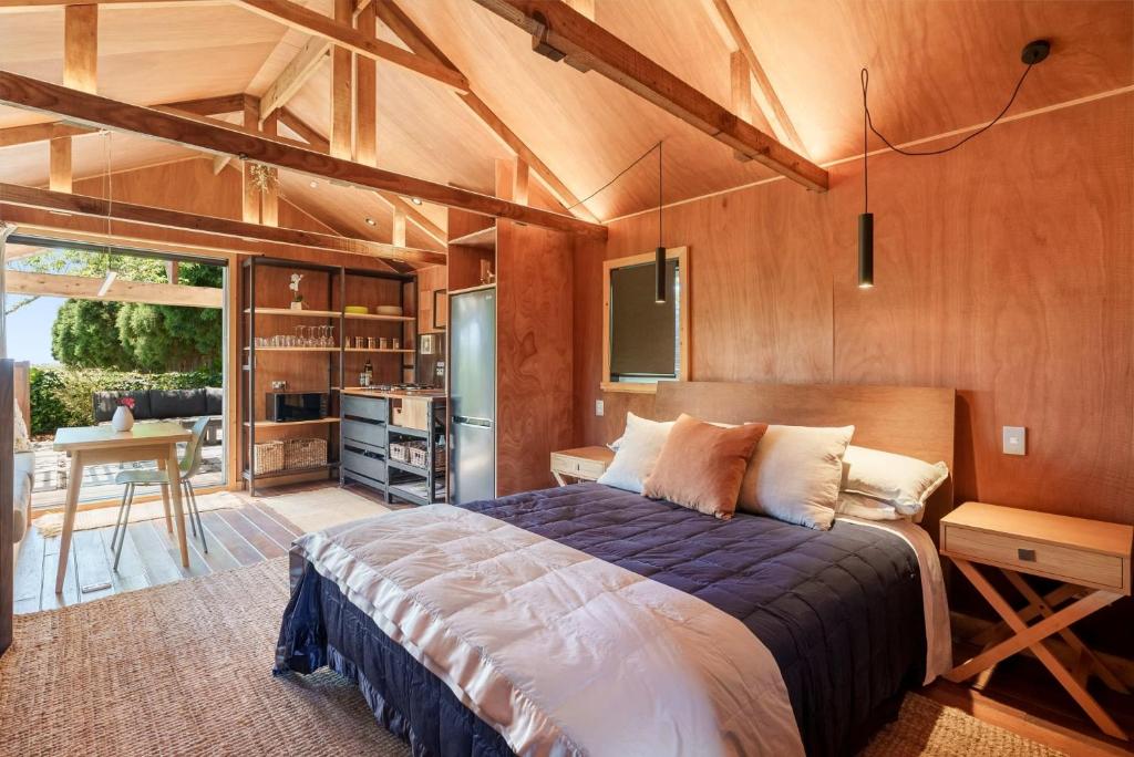 um quarto com uma cama grande e uma cozinha em The Shed Guest House em Mount Maunganui