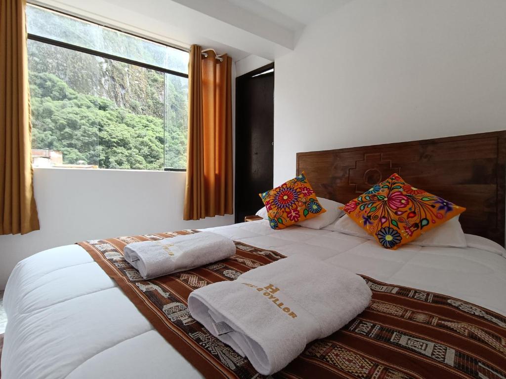 a bedroom with a bed with pillows and a window at CUSI QOYLLOR in Machu Picchu
