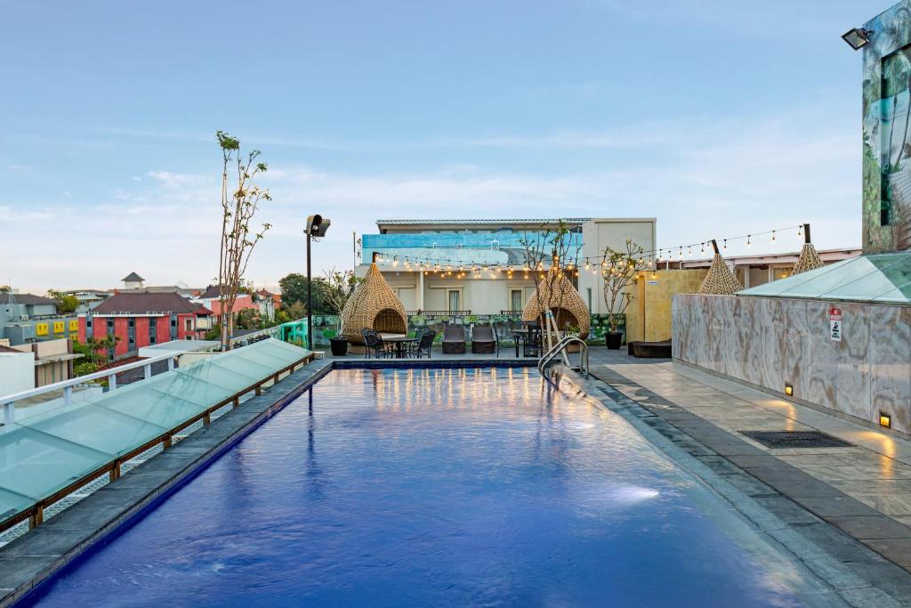 una piscina con un tobogán en el medio de un edificio en Boss Legian Hotel Powered by Archipelago en Legian