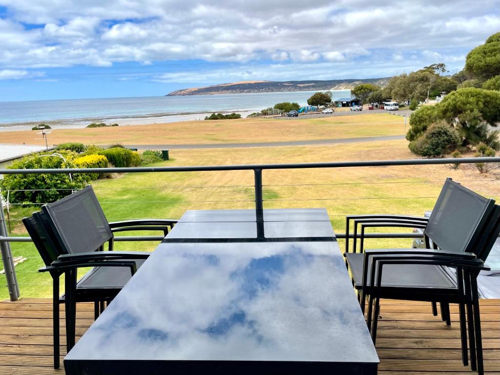 a table and chairs on a deck with a view of the ocean at Hamilton in Emu Bay