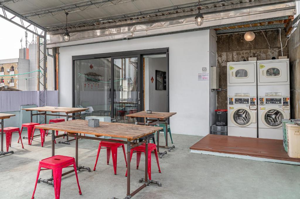 a room with tables and chairs and washing machines at Light Hostel in Chiayi City