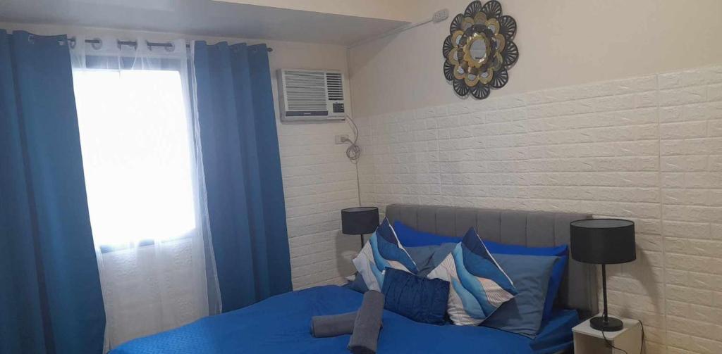 - une chambre avec un lit bleu et une fenêtre dans l'établissement US Embassy Roxas Blvd, Ermita, Manila 1 Bedroom ComfySuite, à Manille