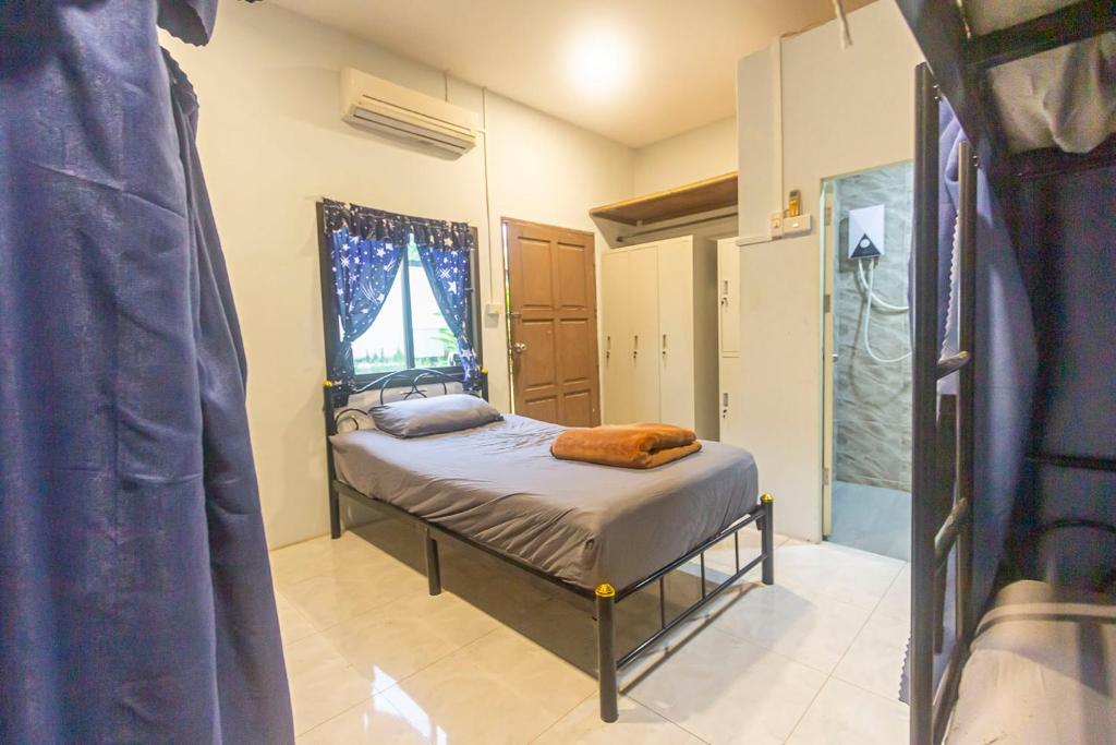 a small bedroom with a bed and a window at The Travelers Friend En Suite dorm room AC in Ban Ai Dao