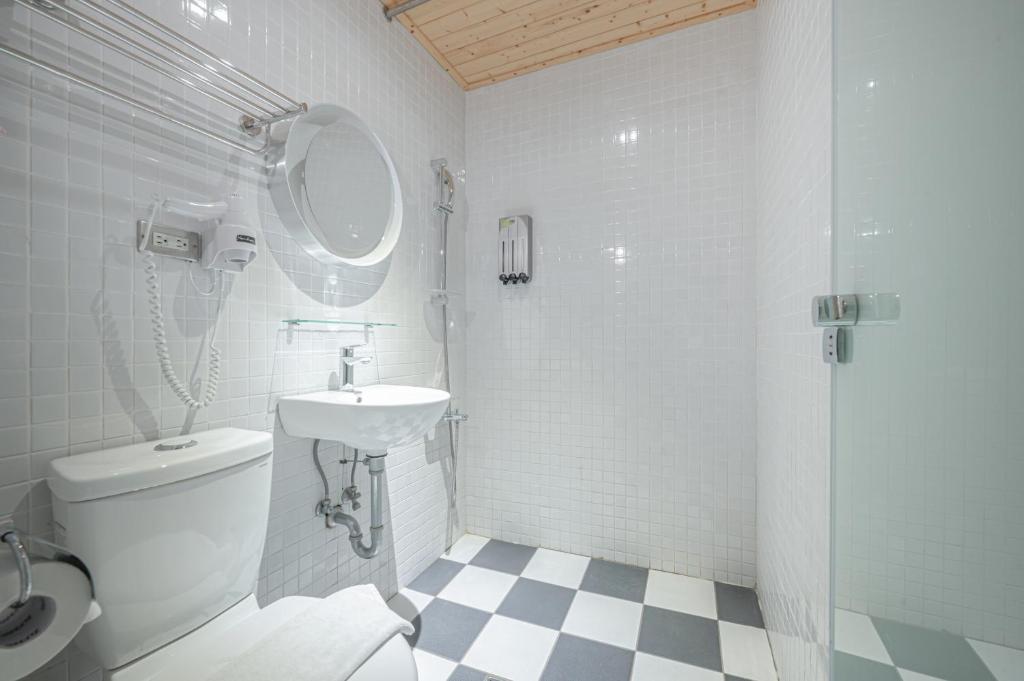 a bathroom with a toilet and a sink and a shower at Light Hostel in Chiayi City