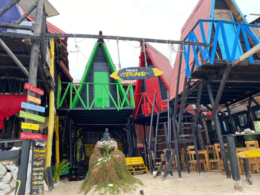 un grupo de edificios coloridos con mesas y sillas en Posada Tipiland la casa del Mono, en Playa Blanca