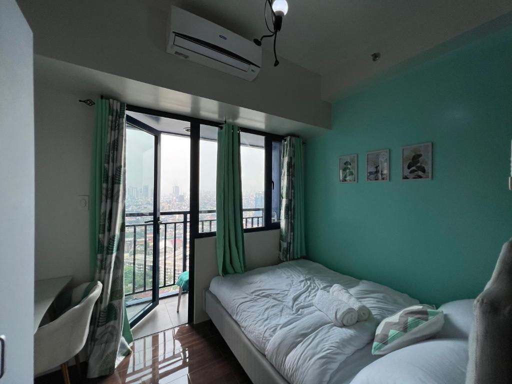 a bedroom with a bed and a large window at Cozy Condo Apartment in Makati / Manila with mall, restaurants, groceries, pool, netflix, disney+ and more in Manila