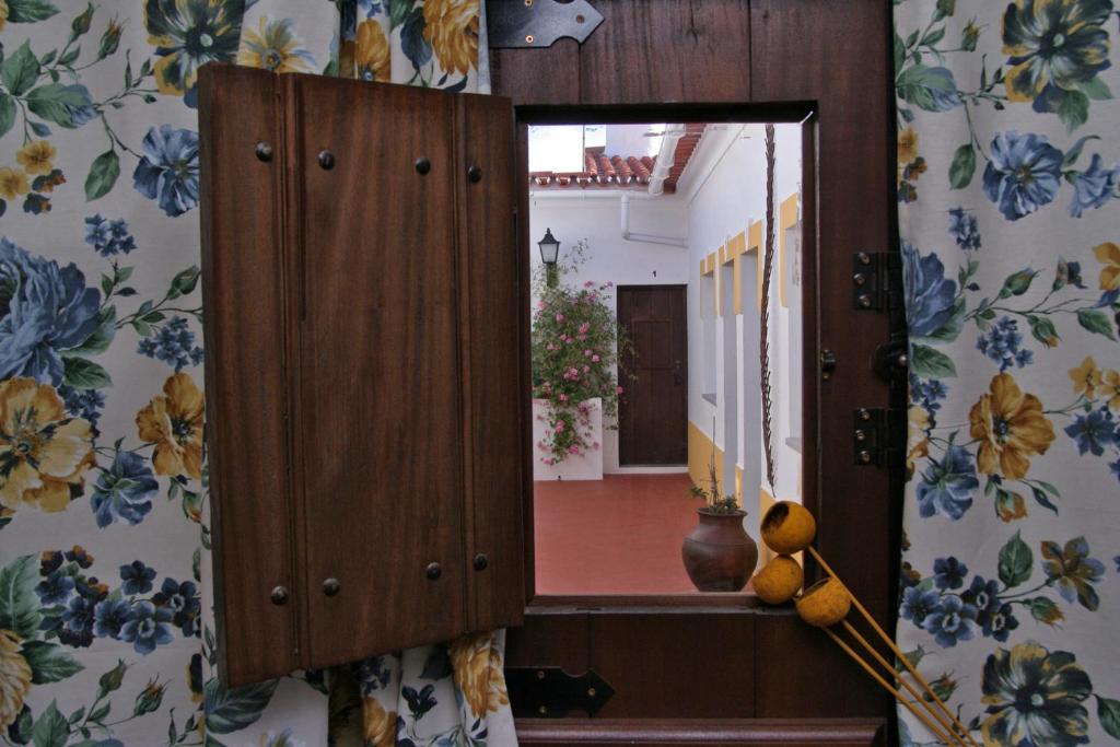 um espelho num quarto com flores na parede em Alojamento Pero Rodrigues em Alandroal