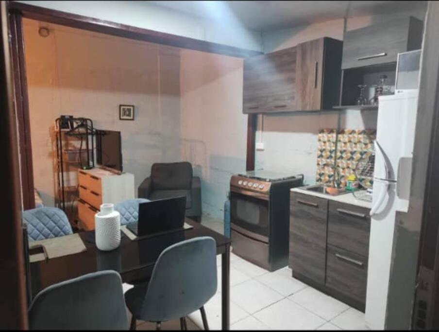 基多的住宿－Minimalist House 1br El Bosque，厨房配有桌椅和笔记本电脑