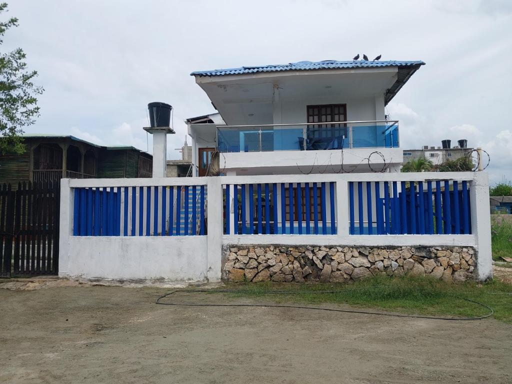 a blue gate in front of a house at Alojamiento villa maría in Coveñas