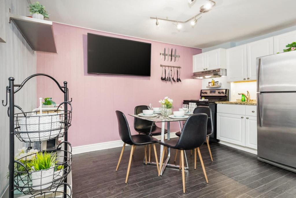 a kitchen with a table and chairs and a pink wall at 2BR Apartment with Private Rooftop Terrace in Ottawa
