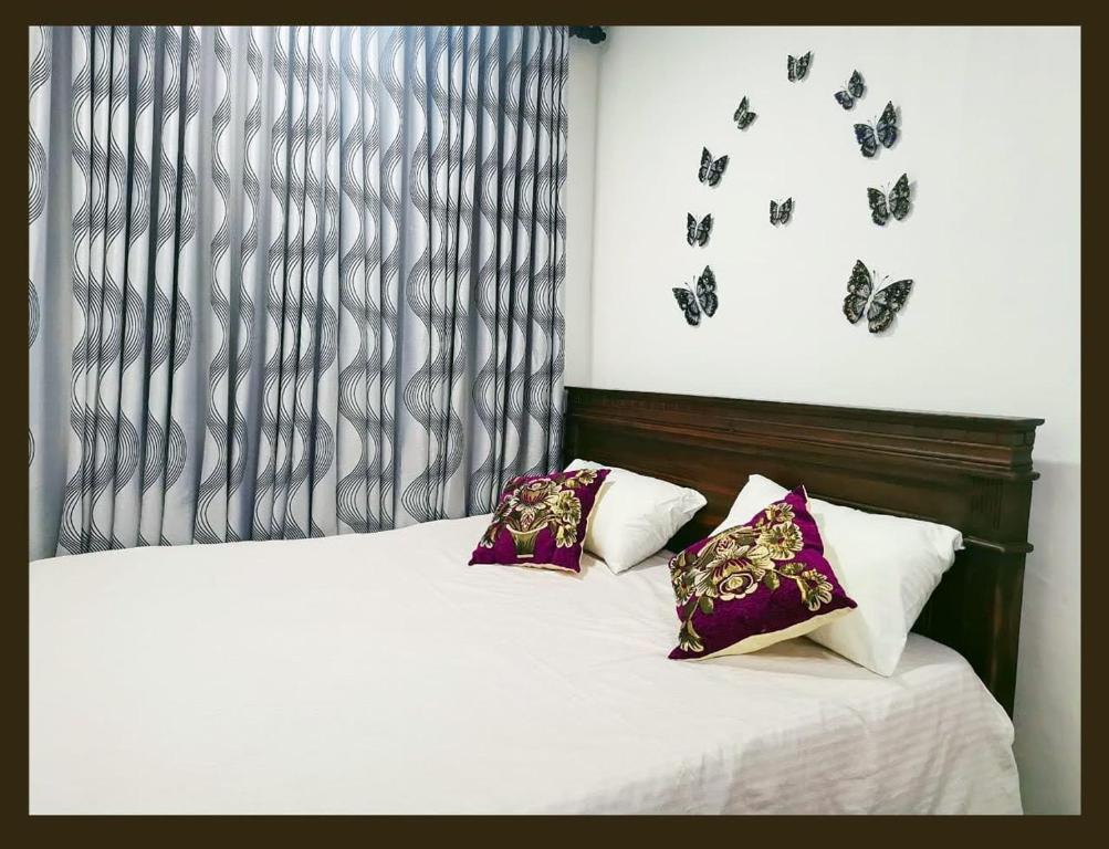 a bedroom with a bed with butterflies on the wall at GREEN GRASS HOUSE in Colombo