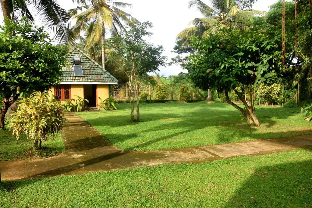 una casa en medio de un exuberante patio verde en Tharindu Villa en Dankotuwa