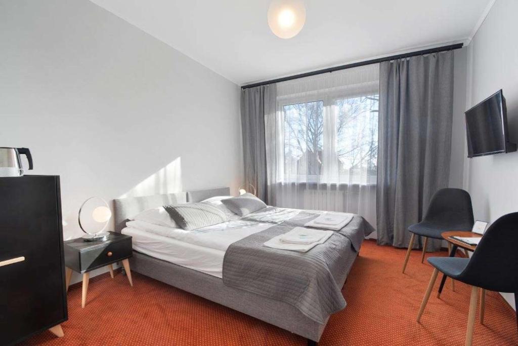 Un dormitorio con una cama y una ventana grande. en Resort Moderna Jastrzębia Góra, en Jastrzębia Góra