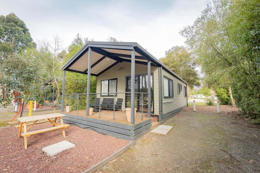 a tiny house with a porch and a picnic table at BIG4 Breeze Holiday Parks - Eildon in Eildon