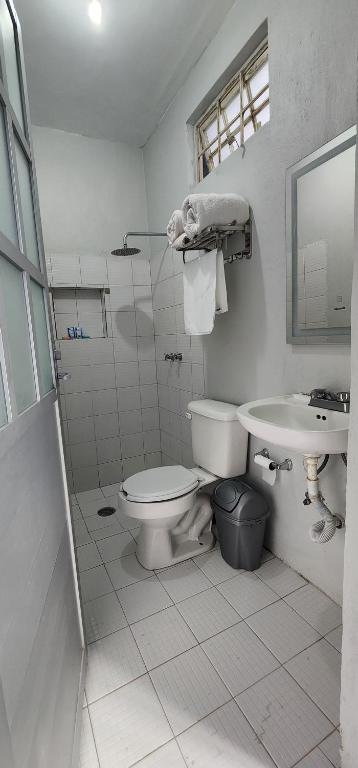 Baño blanco con aseo y lavamanos en Departamento por plaza terraza oblatos en Guadalajara