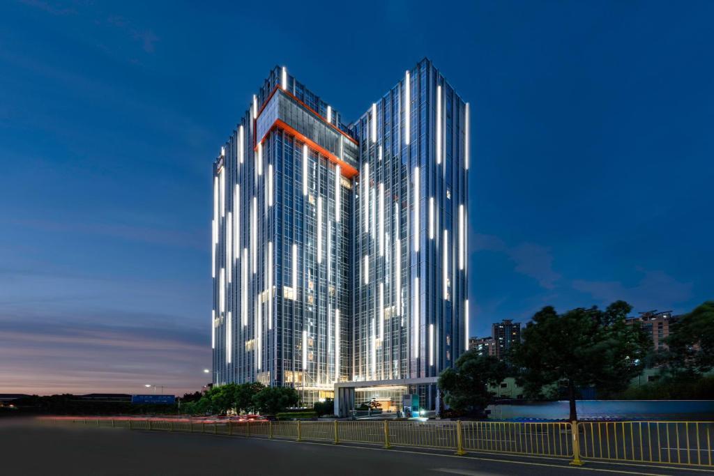 a rendering of a tall building at night at Sha Zhi Ye Serviced Apartment Hotel - Houjie Wanda Plaza Liaoxia Subway Station in Dongguan