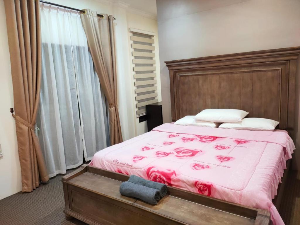 Al Hidayah Suite في بندر سيري بيغاوان: غرفة نوم بسرير مع شراشف وردية وورد
