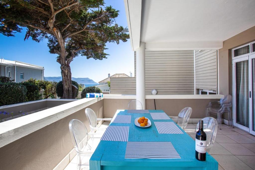 a blue table and chairs on a balcony with a bottle of wine at Harmony Haven in Cape Town