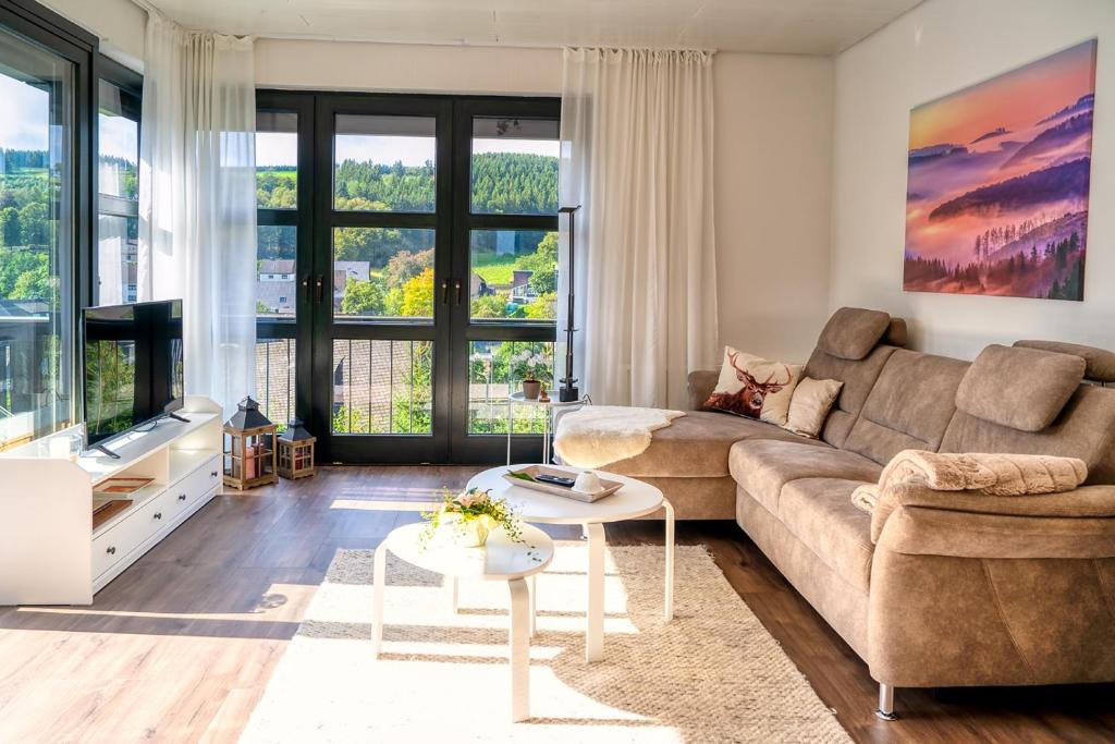 uma sala de estar com um sofá e uma televisão em Sunside Winterberg em Winterberg