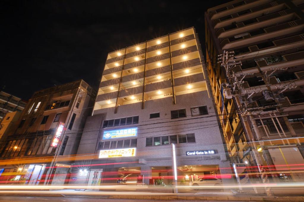 un edificio alto con luces encendidas por la noche en Coral Gate in Kume コーラルゲートイン久米, en Naha