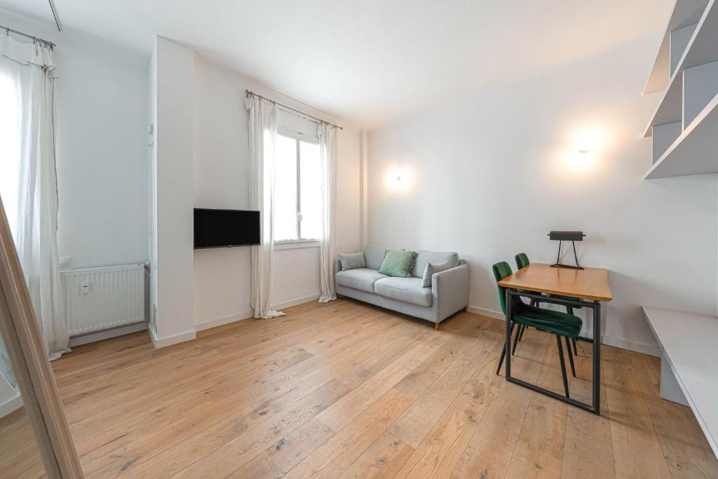 salon ze stołem i kanapą w obiekcie Appartement Architecte Catalans- Bord de mer w Marsylii