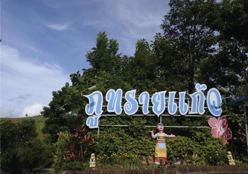 a young boy standing under a sign with the word mazaho at ภูทรายแก้วรีสอร์ทวังน้ำเขียว in Wang Nam Khieo