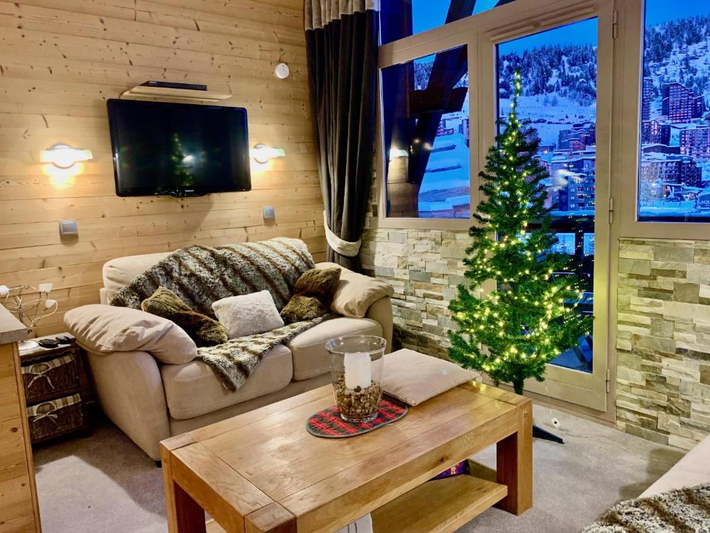 a living room with a christmas tree and a couch at Luxury Chalet with sauna by Avoriaz Chalets in Avoriaz
