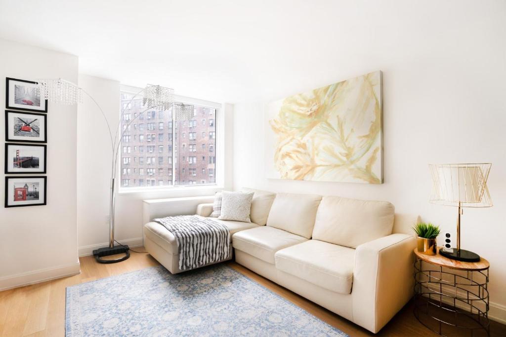 a living room with a white couch and a window at Lovely 2 Bedroom Apartment in New York