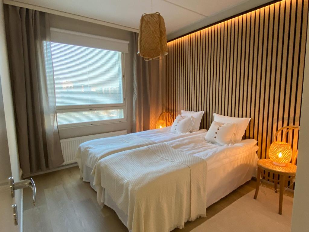 um quarto com uma grande cama branca e uma janela em Upea saunallinen kaksio Sibeliustalon vieressä em Lahti