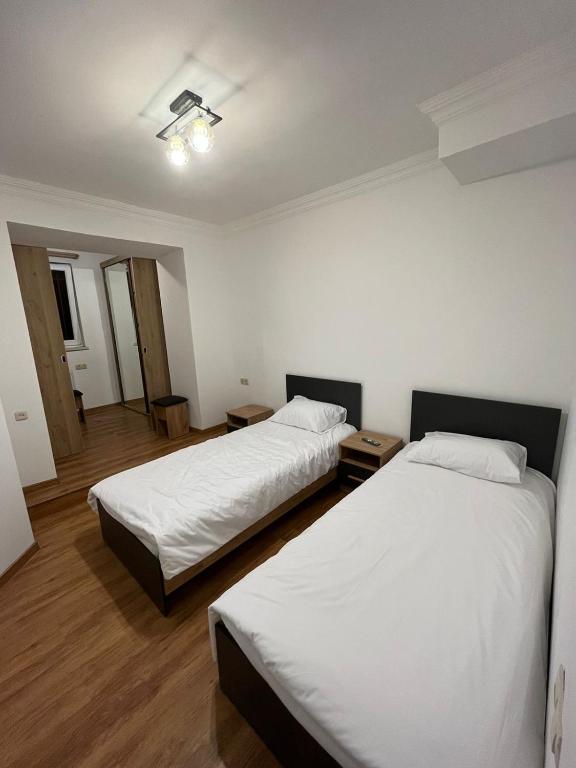- 2 lits dans une chambre avec des draps blancs dans l'établissement Rostovyan 17 Home 3, à Erevan