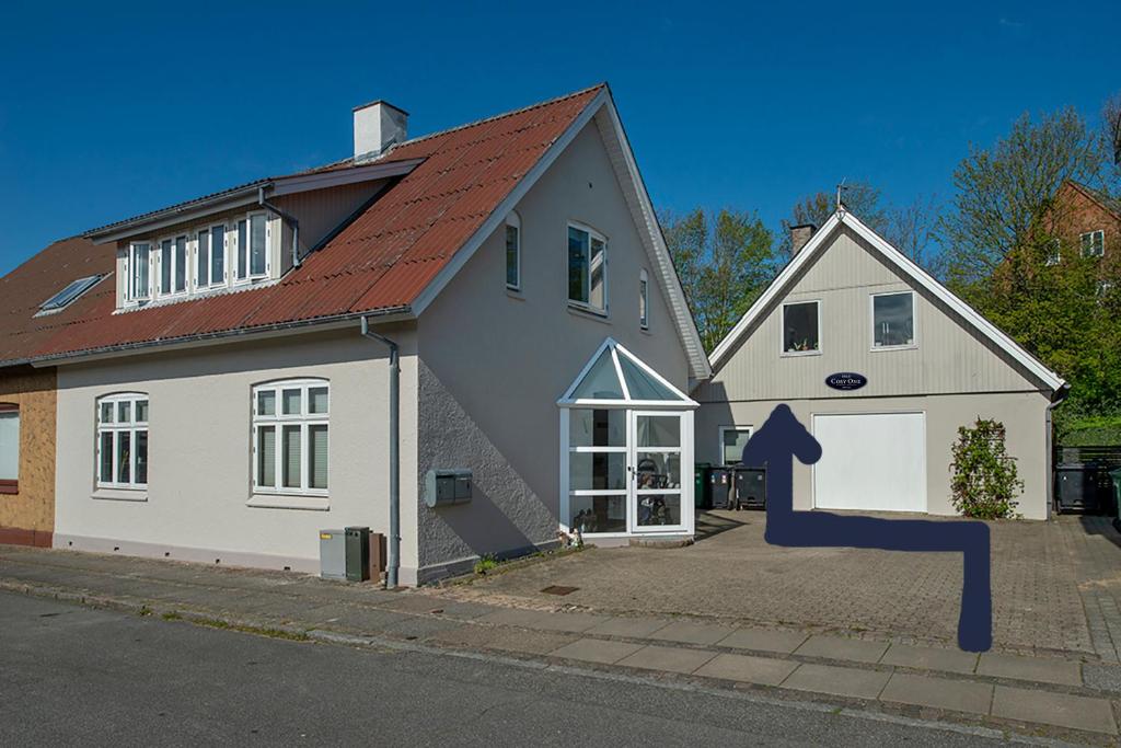 uma grande casa branca com um telhado vermelho em Cosy One Villa em Struer